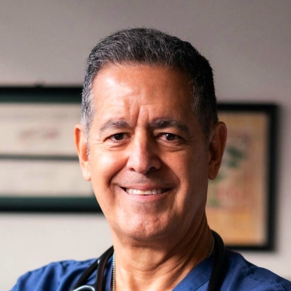 Photo du Dr Bouaziz, chercheur en immunologie à l'hôpital Saint Louis. Il porte une blouse de médecin et sourit à l'objectif.